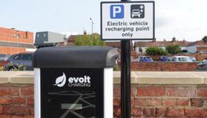 The top third of an Evolt Charging EV charger along with EV signage.